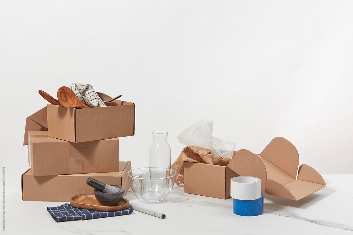 Open cardboard boxes with dishware and glassware.