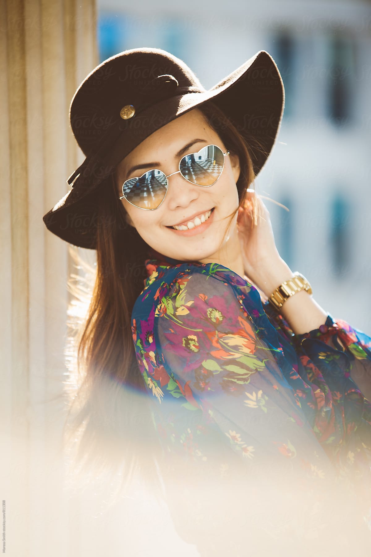 Smiling happy young lady in a floppy hat in the afternoon light