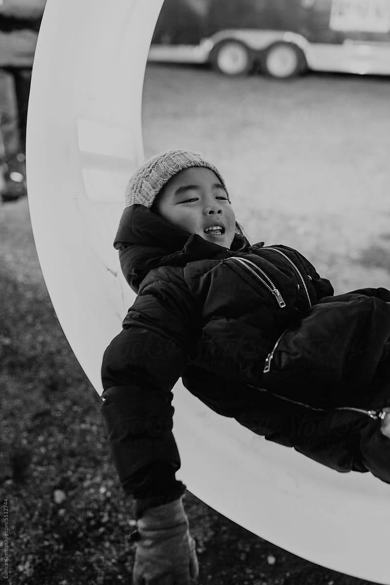 Young girl laying on an outdoor swing