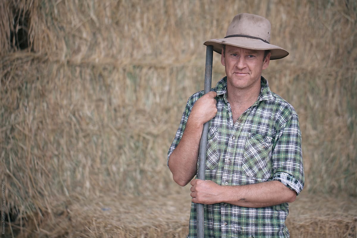 Farmer in hay barn holding a pitchfork