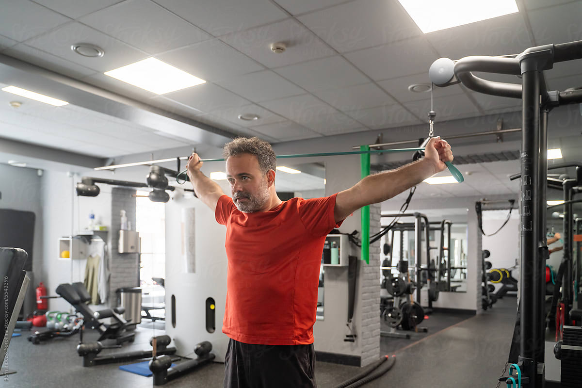 Man Exercise Using Resistance Band At Gym