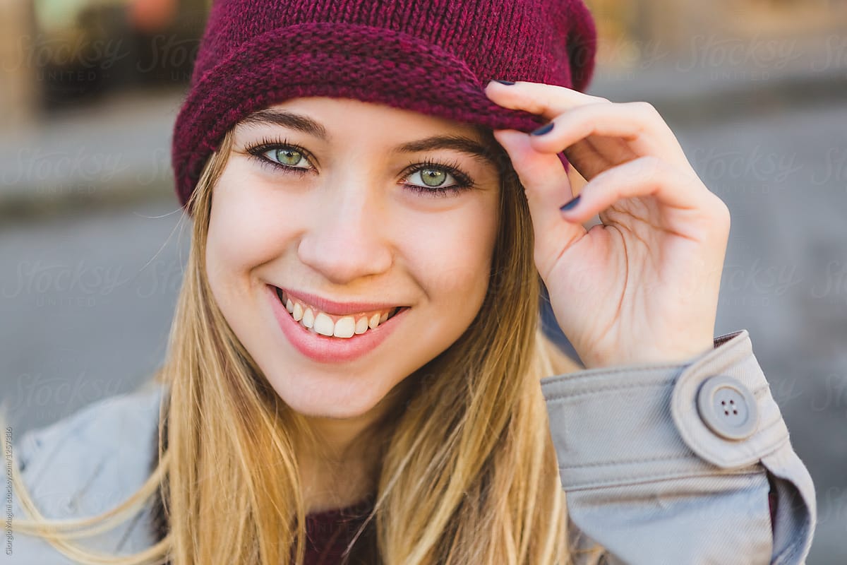 Smiling Teenage Girl Wearing a Purple Beanie during the Cold Season