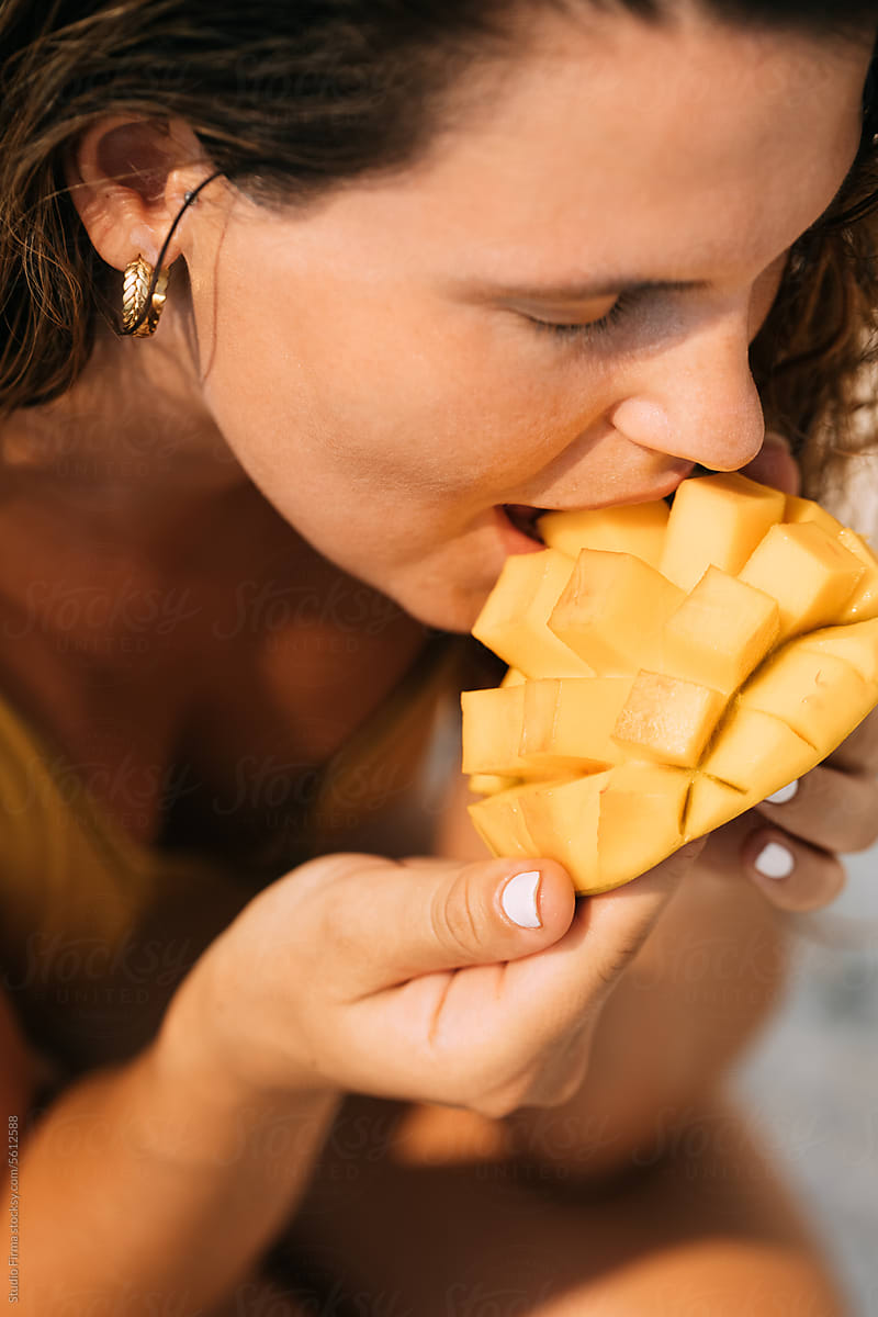 Woman Eating Mango at Beach