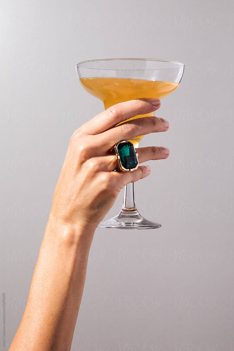 Woman\'s hand with a ring holding a glass