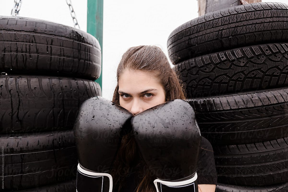 Young woman with kick boxing gloves outdoors