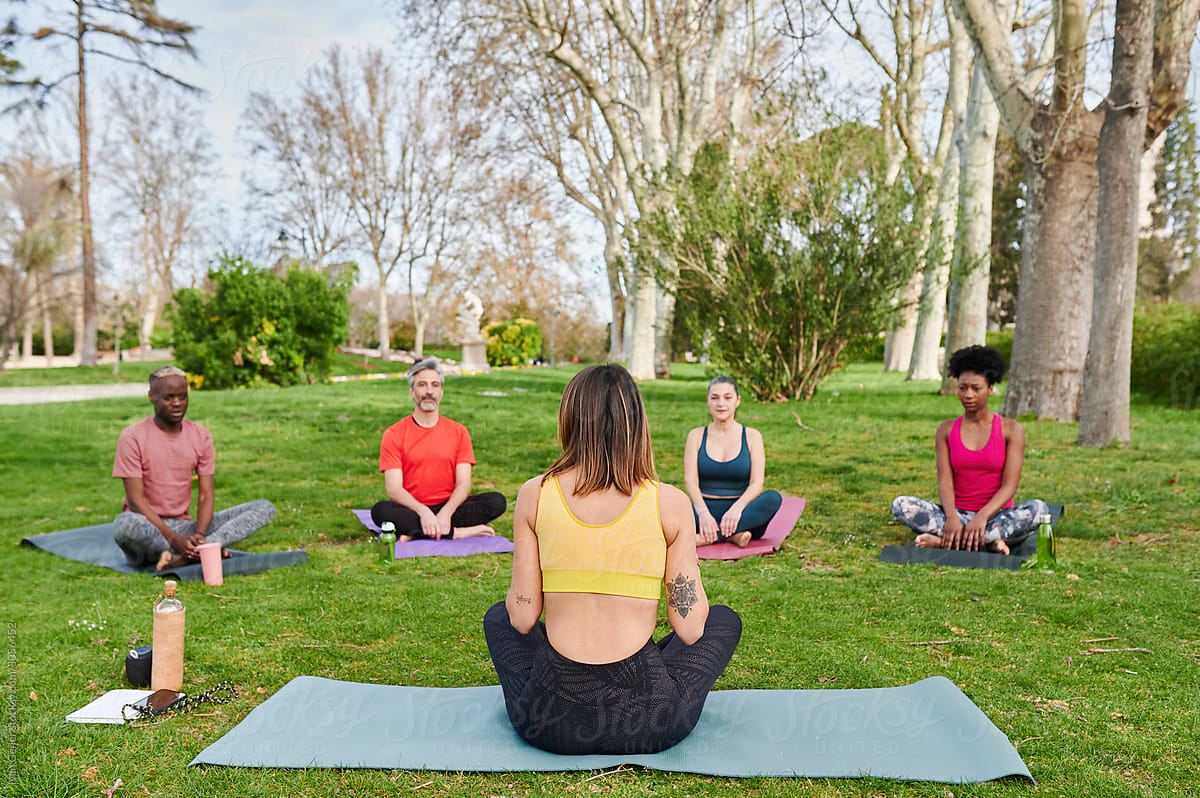 Yoga teacher talking with students in a park