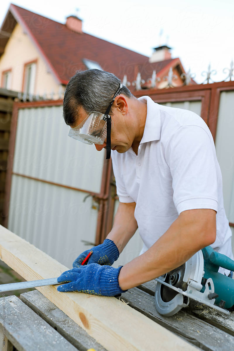 a man processes wood in the yard