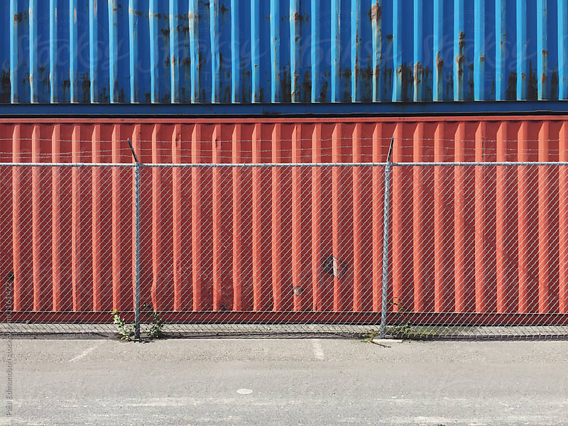 Stacked cargo containers, chain link fence in foreground