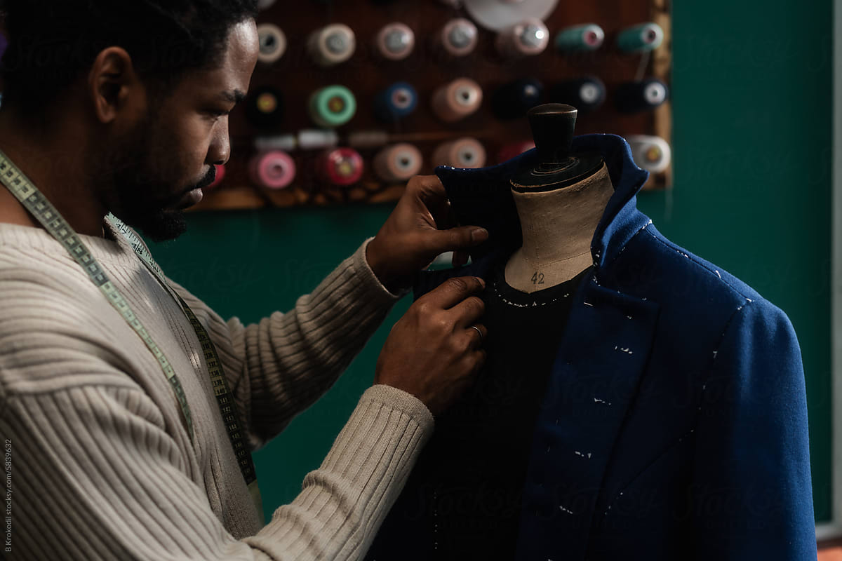 Close Up Of Male Tailor Working On The Coat Design In His Workshop