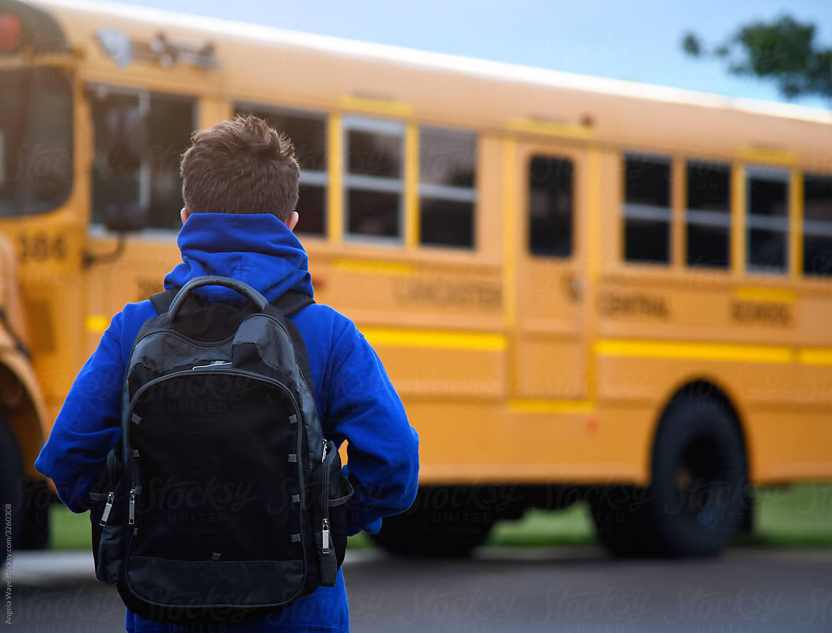 Student Standing Outside by School Bus