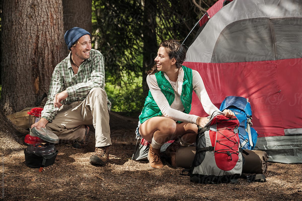 Outdoorsy Couple Unpack and Set up Camp in the Woods