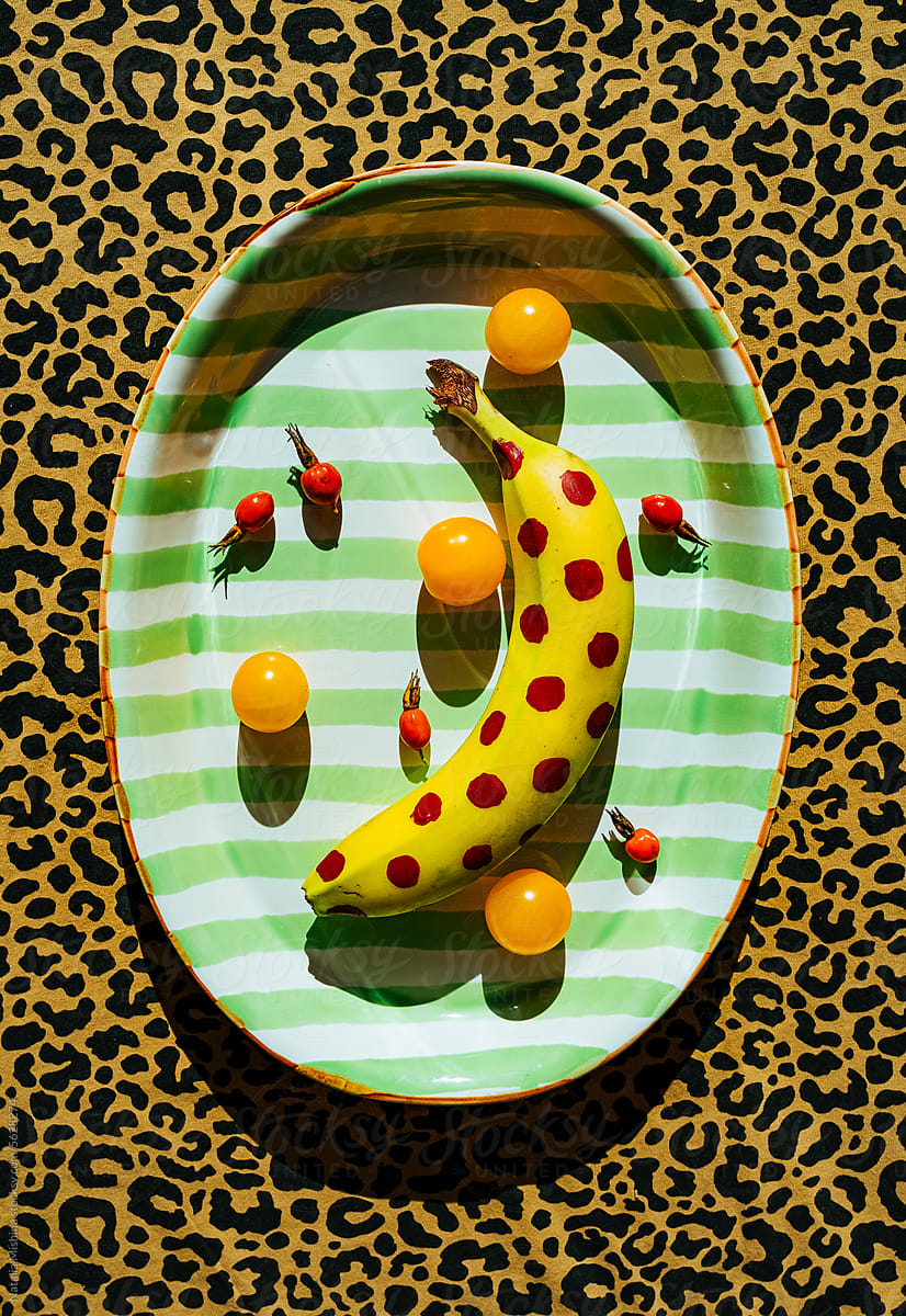 A dish with a banana on a leopard tablecloth.