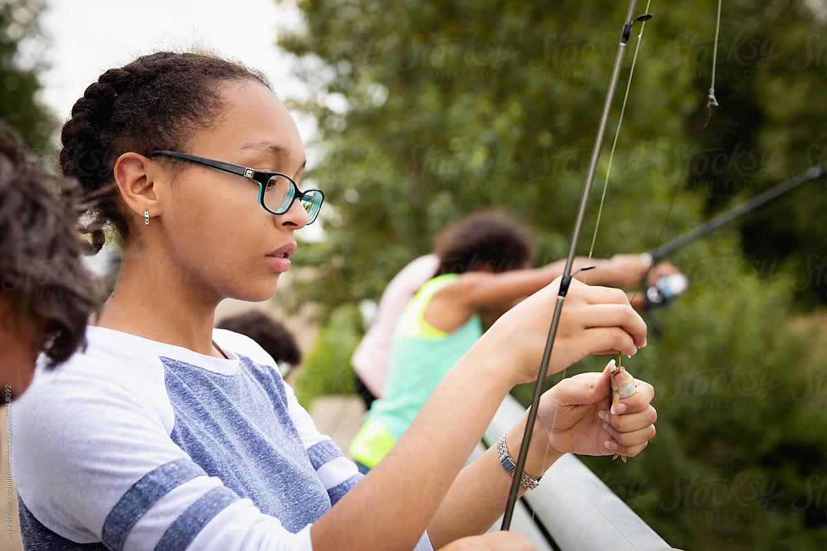 Teen Girl Removing A Small Fish From Her Fishing Hook. by Stocksy  Contributor Anya Brewley Schultheiss - Stocksy