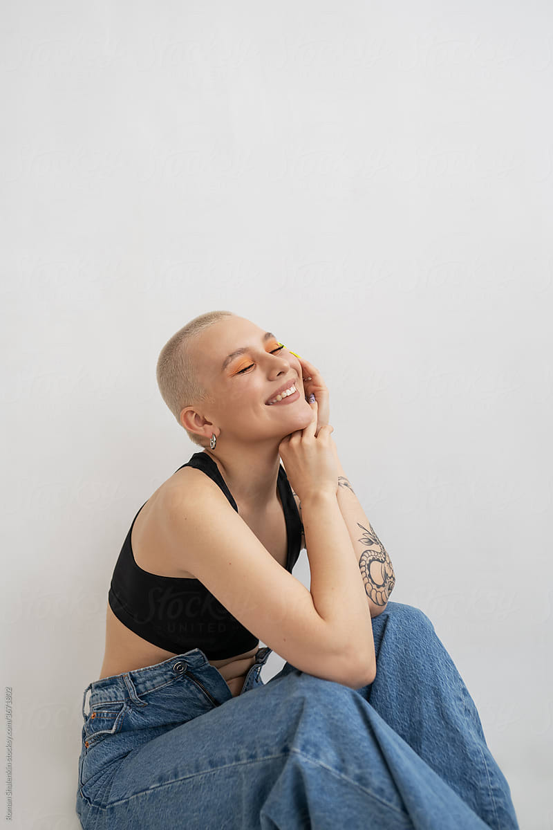 Cheerful happy informal young woman with short hair and tattoo