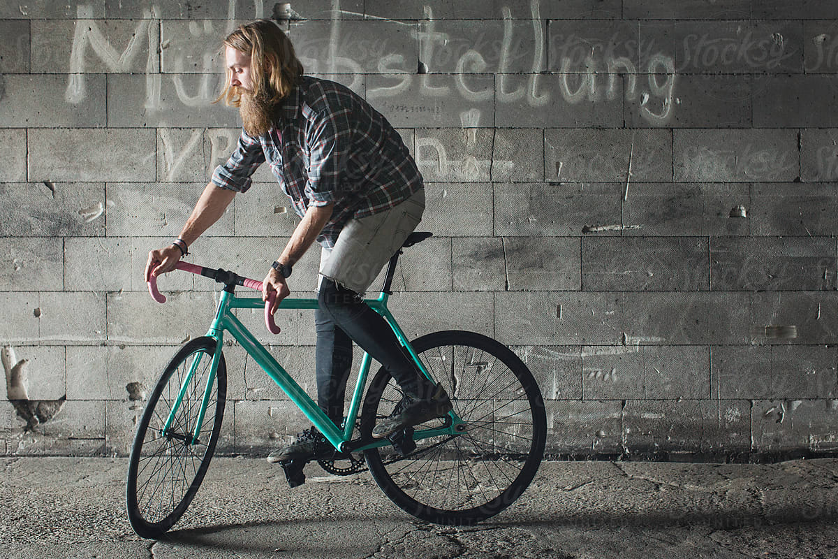Young Guy With Long Hair and Beard Balancing on Fixie