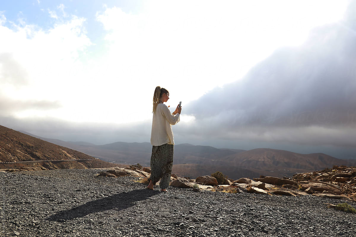 Young woman making picture of view