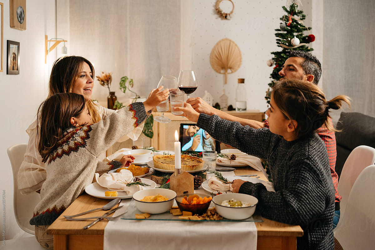Loving family toasting for christmas while congratulating family in video chat