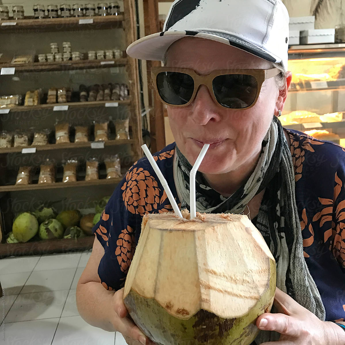 Tourist in Bali drinking fresh coconut drink, UGC smartphone photo
