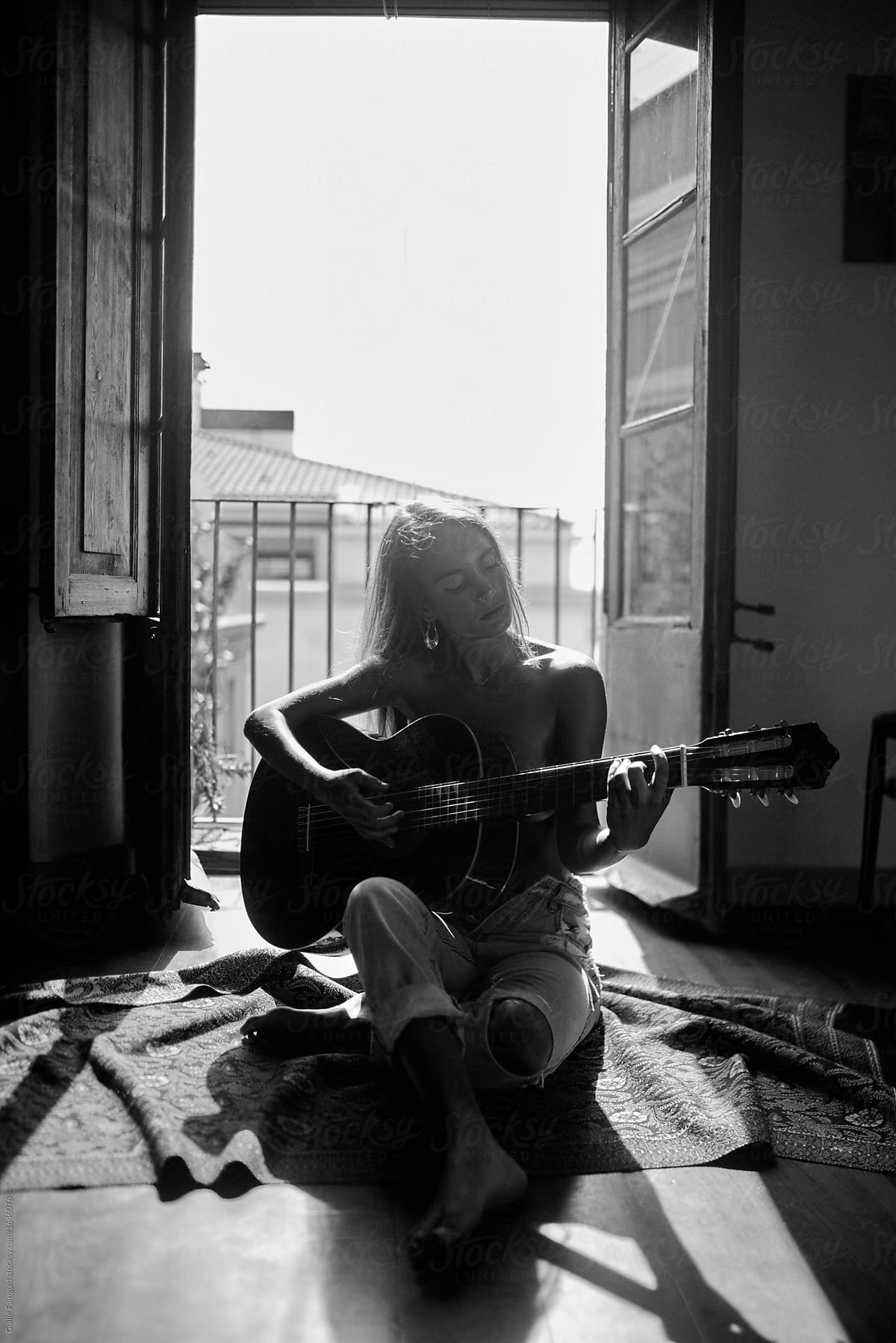 Woman Playing The Guitar Against Opened Balcon By Stocksy Contributor Guille Faingold Stocksy 