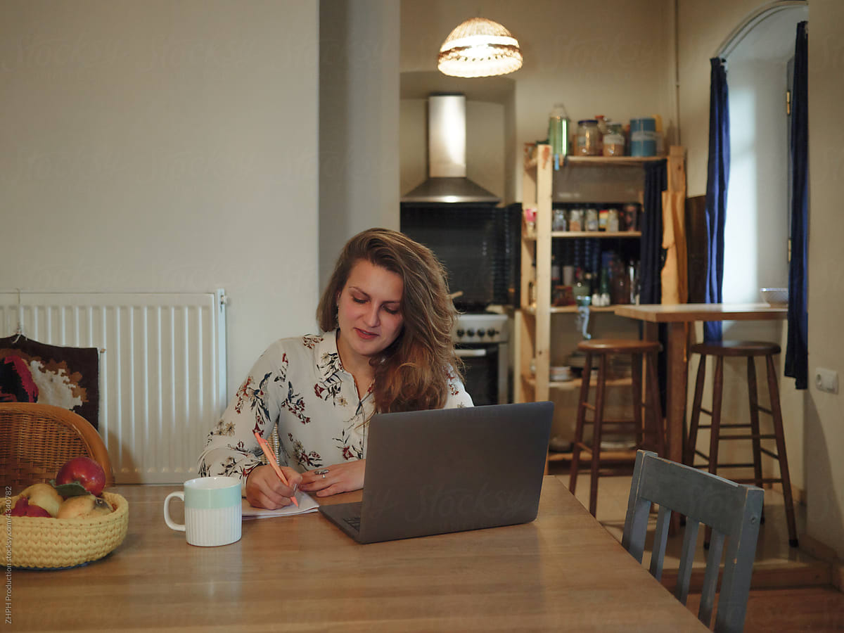 Young woman working on laptop evening at home