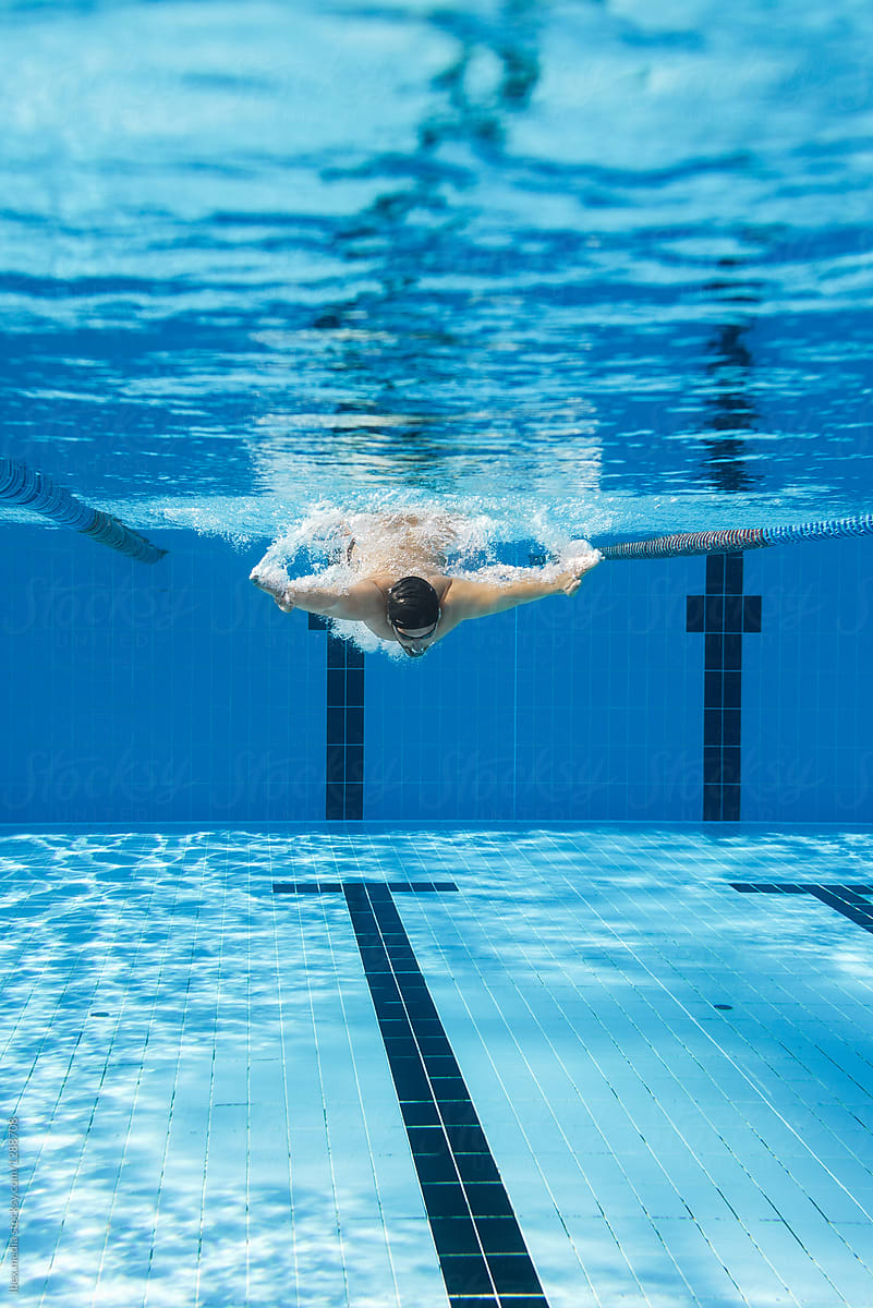 Male Athlete Swimming Underwater In The Swimmingpool By Stocksy