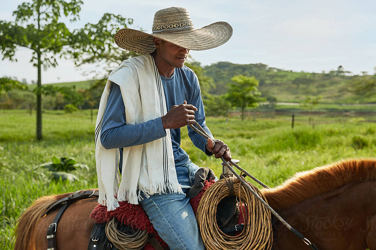Young cowboy portrayed riding on his horse on a Colombian farm