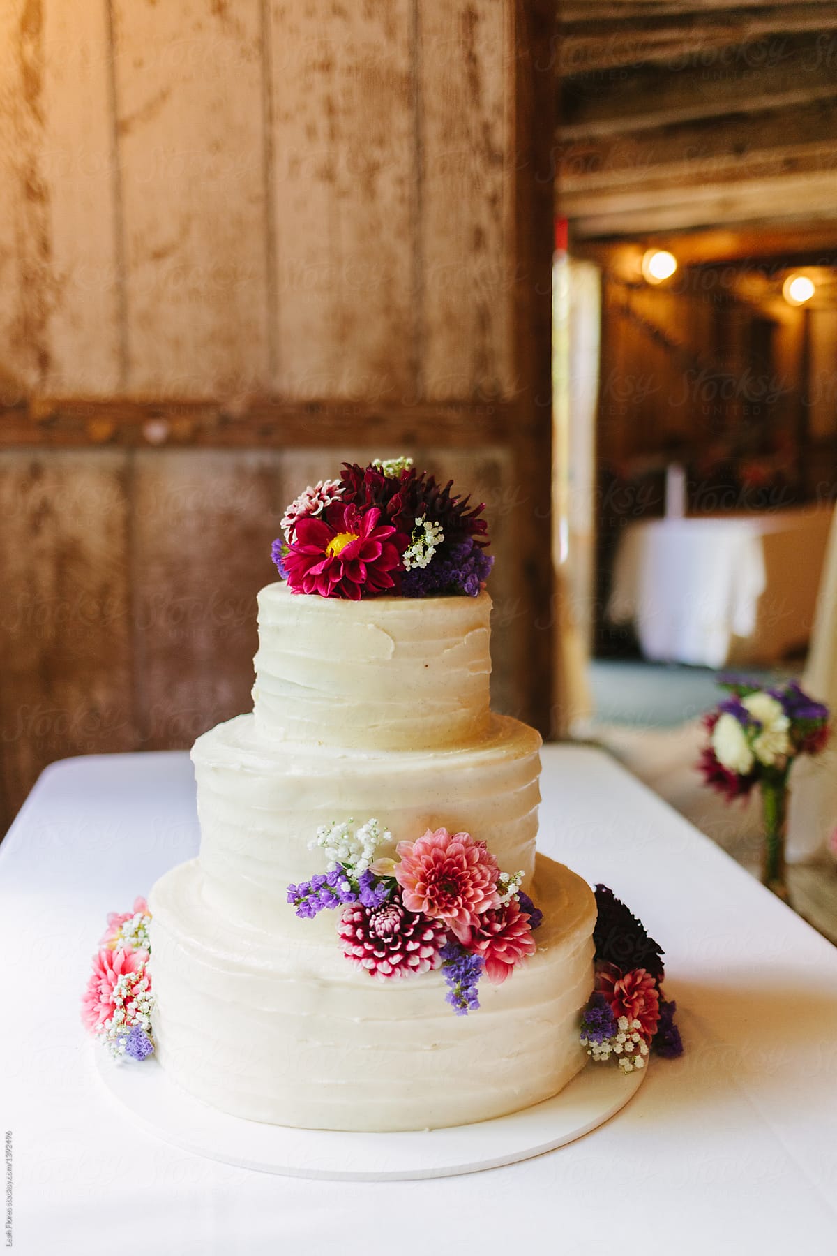 Cake at Wedding Covered in Pink and Purple Flowers