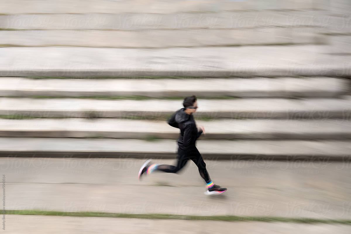 Sportive woman runs on the city embankment