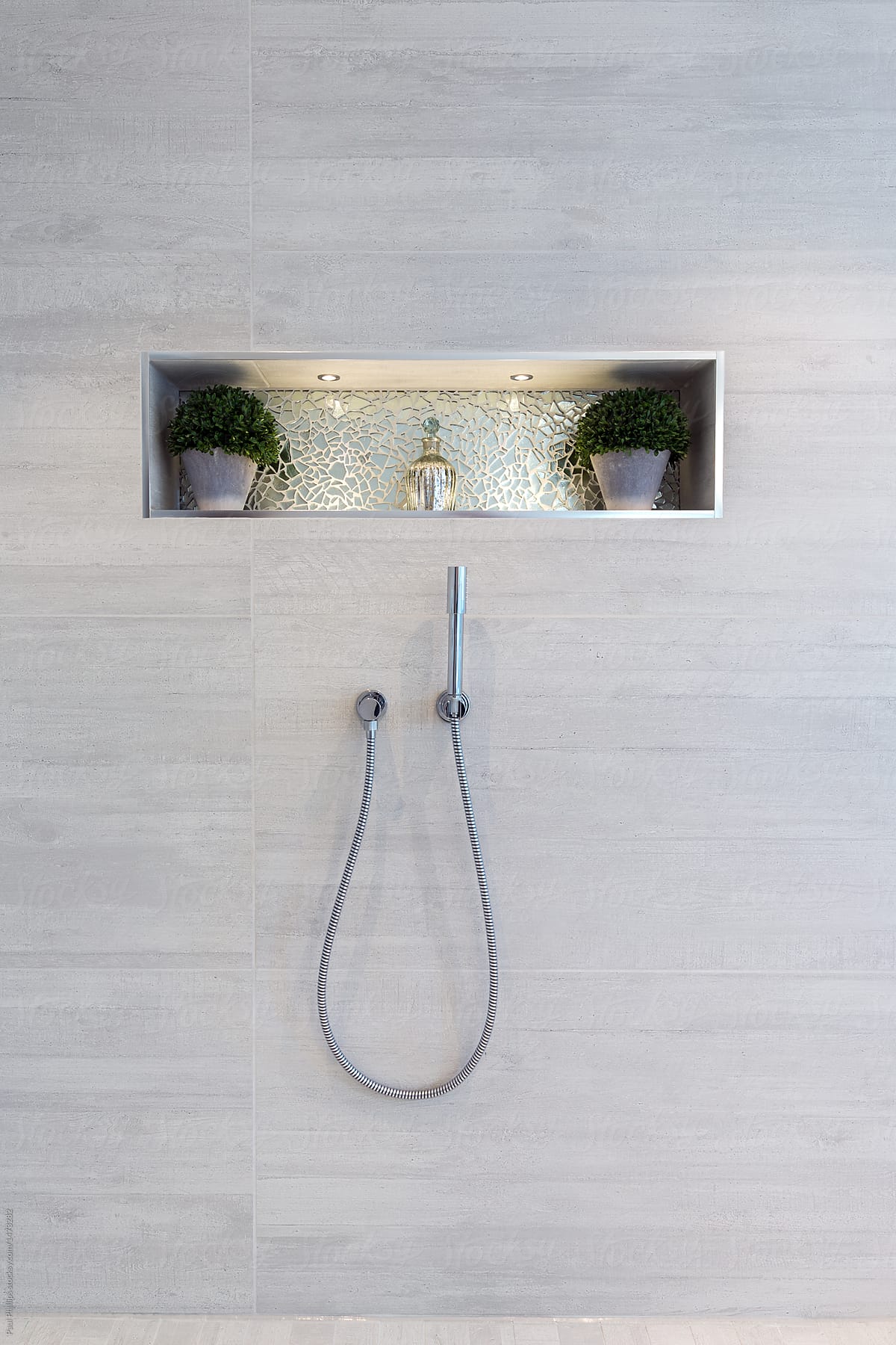 Inset shelf and shower head in a contemporary wet room.