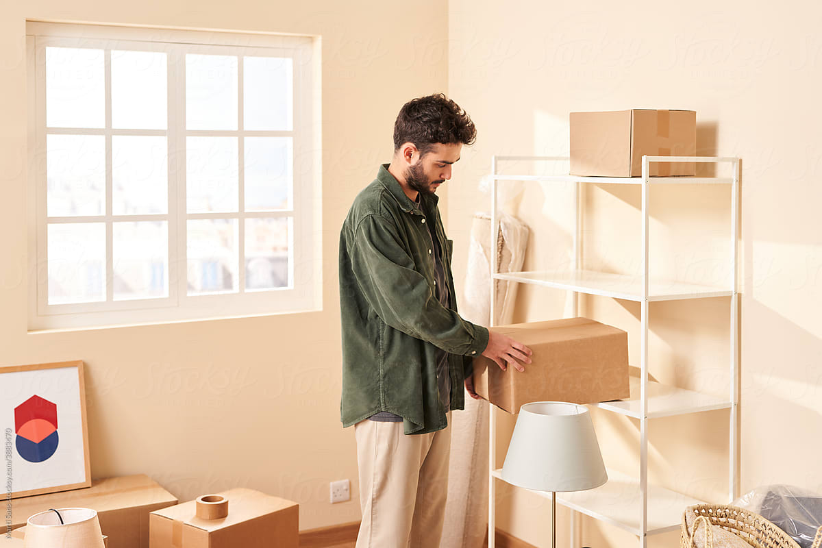 Man unpacking boxes in new apartment