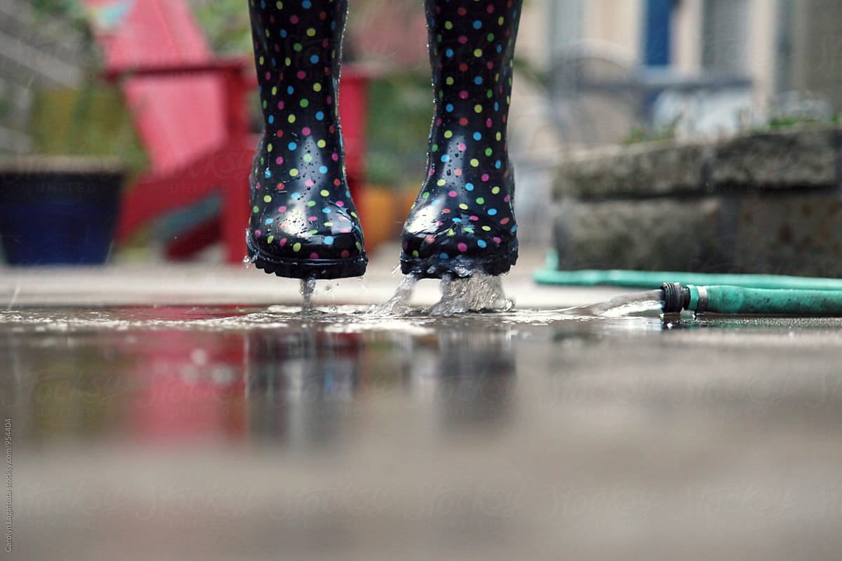 Rain boots jumping with water from the hose