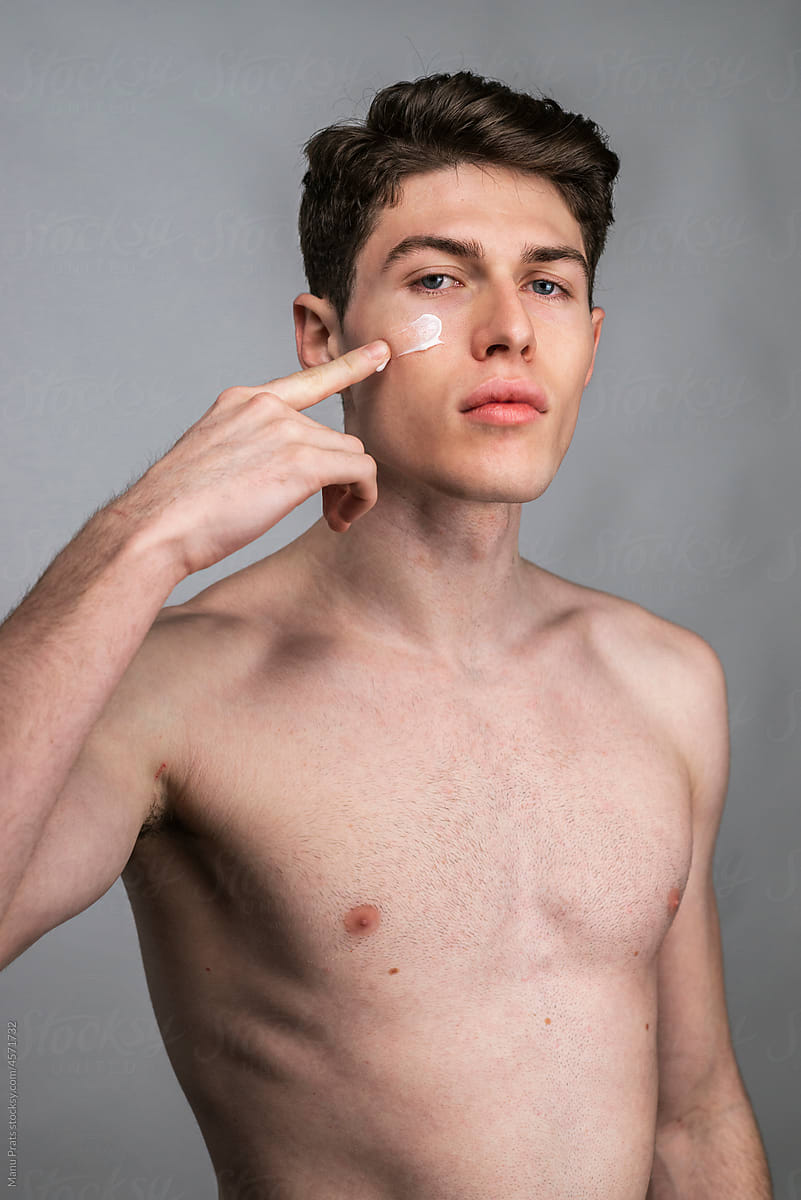 Male skin care, man applying facial cream