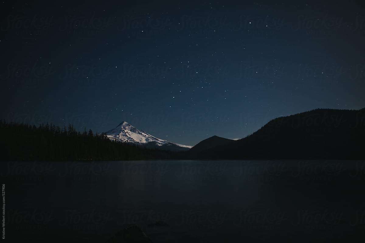 Snow covered mountain at night with stars in the sky