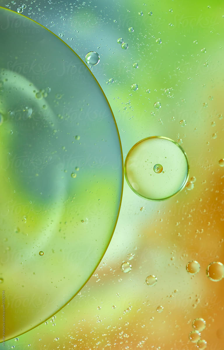 Green And Orange Oil Drops On Water Surface