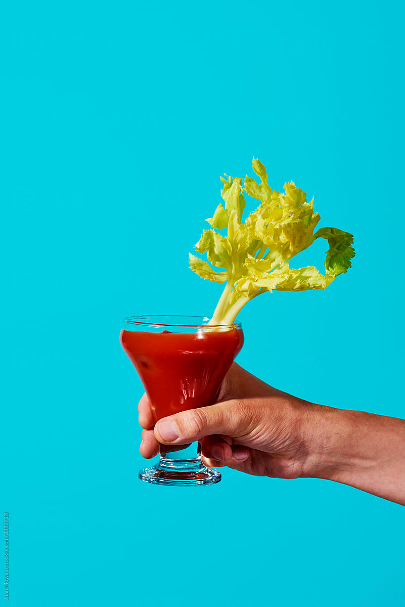 man has a glass of bloody mary in his hand