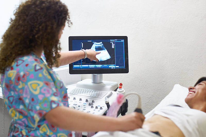 Medical technician talking to her patient during an ultrasound exam