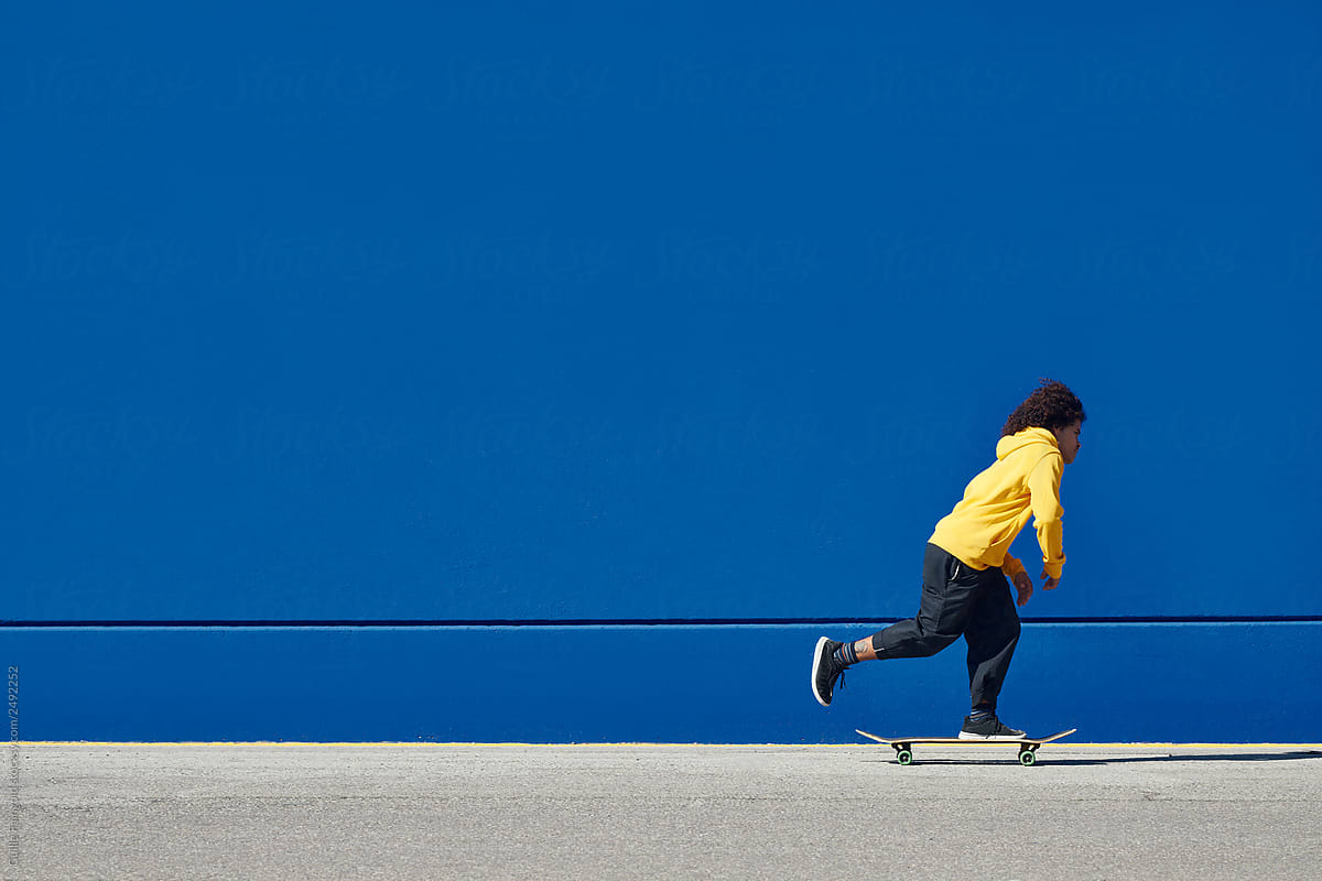 Ethnic man on skateboard on street