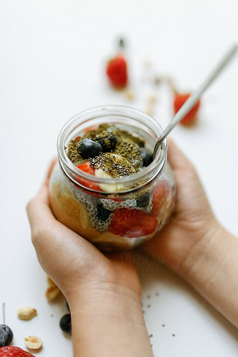 Hands Holding Cup of Chia Seed Pudding Fruit Bowl