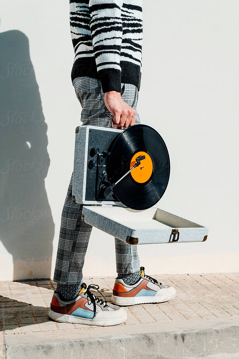 man carries a portable turntable