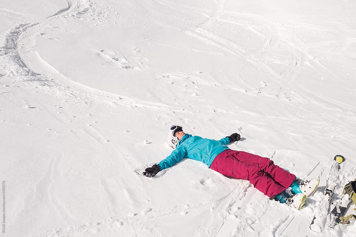 Exhausted female skier lying down in the snow