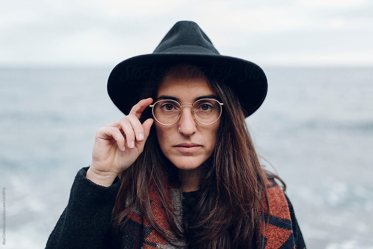 Woman With A Black Hat Scarf And Glasses Looking At The Camera Near