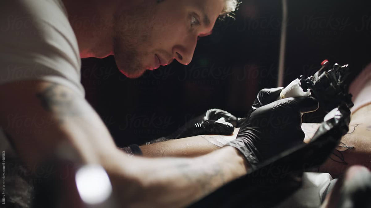 Tattooist Wiping Ink During Session" by Stocksy Contributor "Milles Studio" - Stocksy