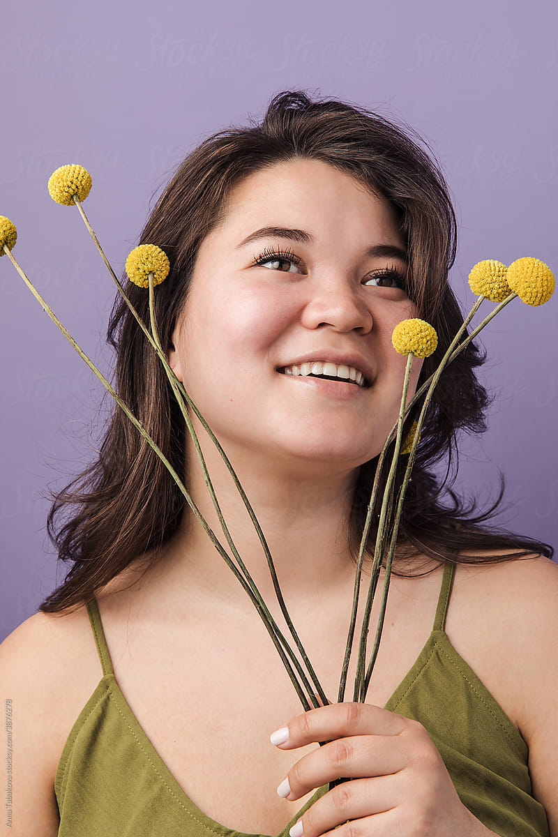 Portrait of a woman with yellow craspedia flowers