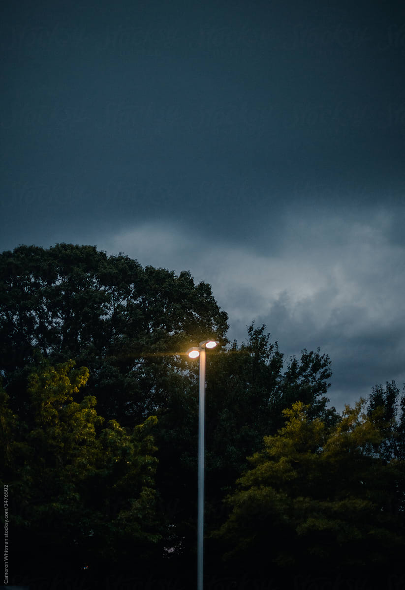 Sturdy and tall parking lot lights against an ominous sky