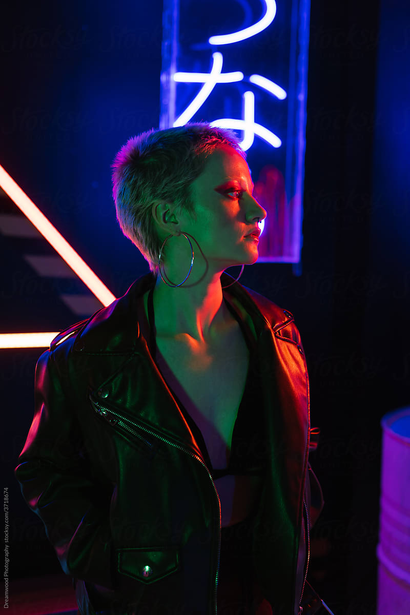Stylish woman with bright makeup in neon lights