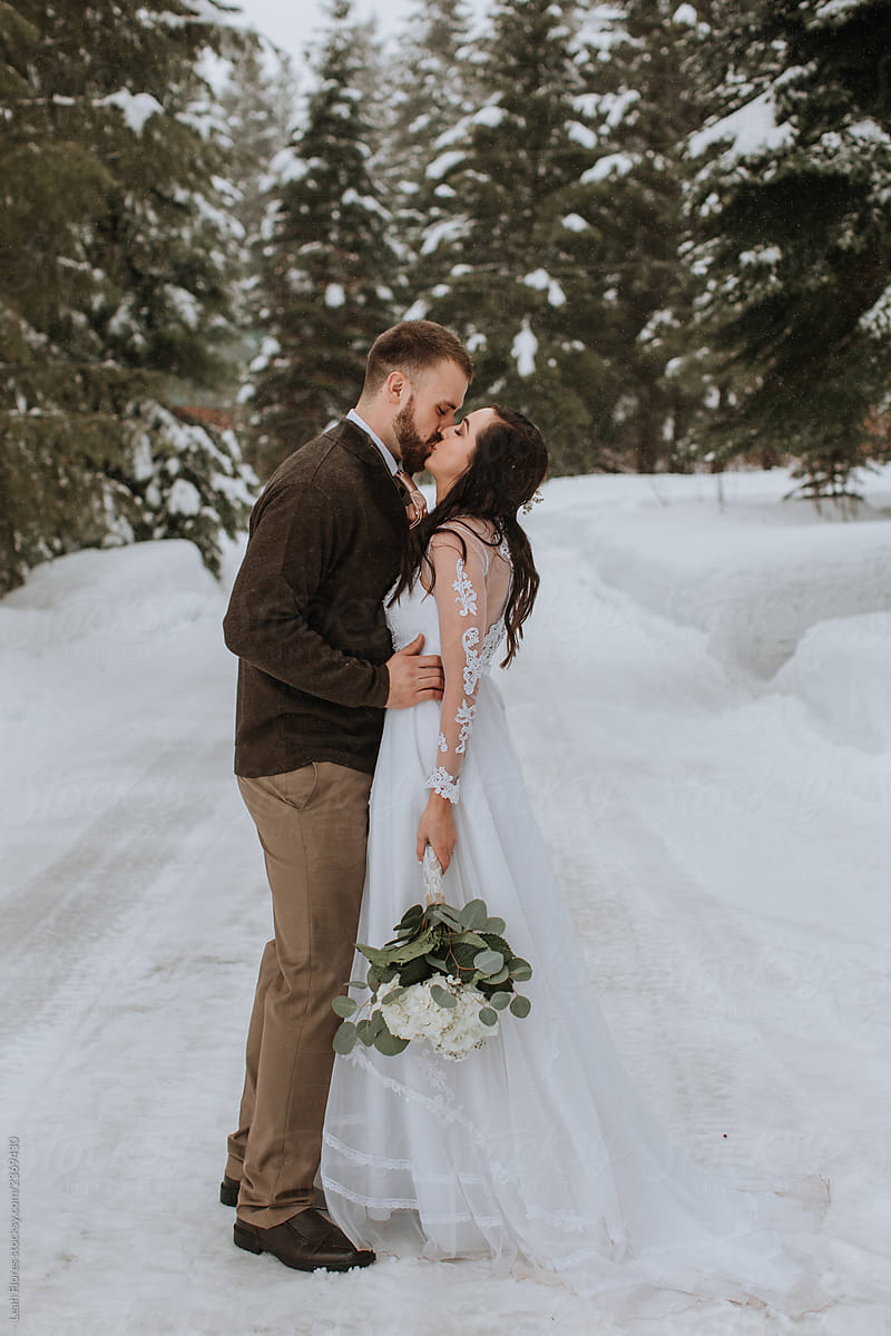 Wedding Couple Kissing in Winter Landscape