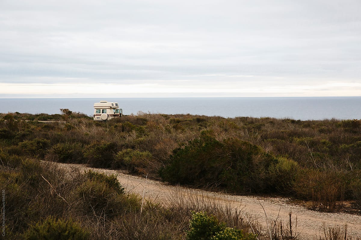 RV camper parked surrounded by nature and ocean