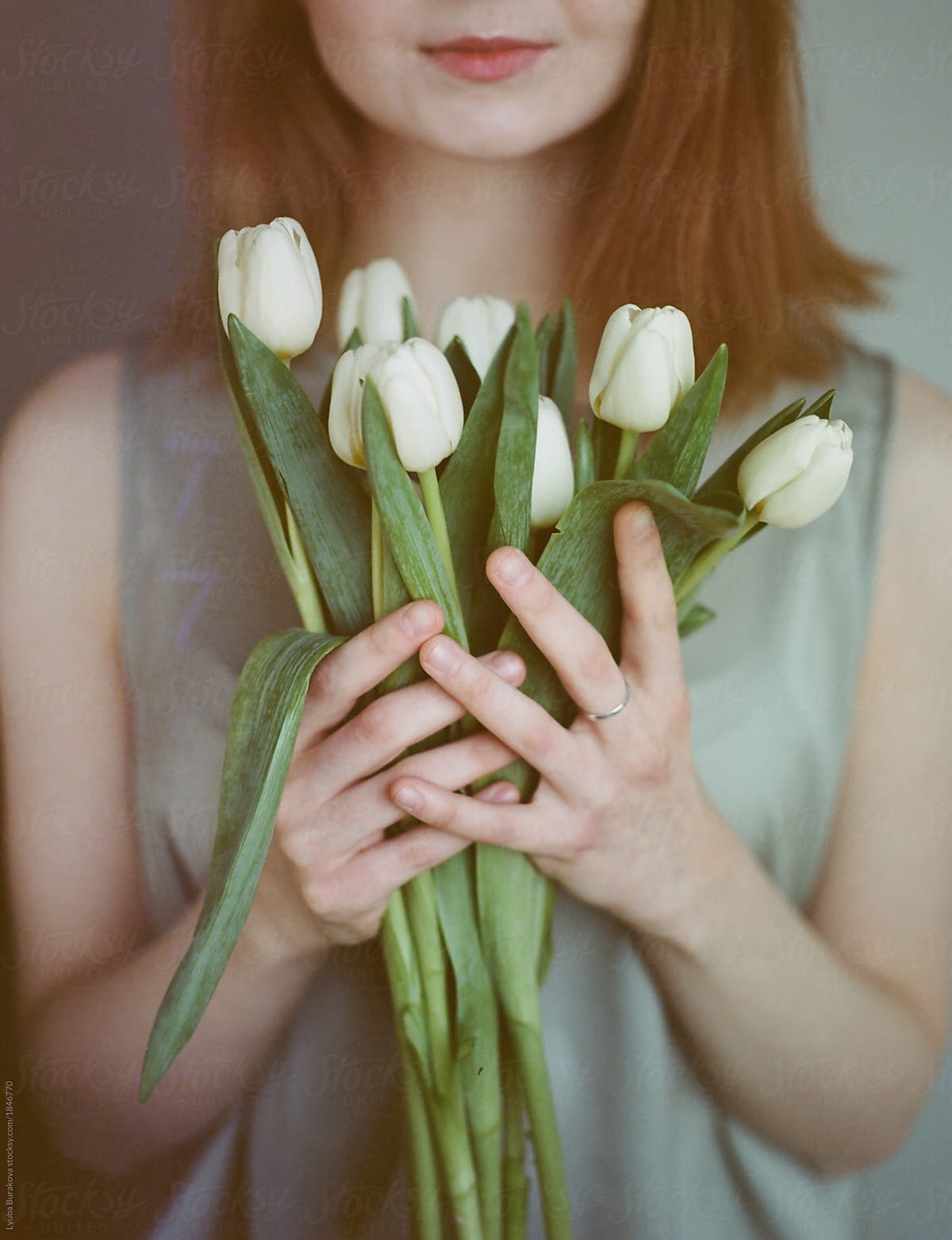 Woman holding banch of white tulips