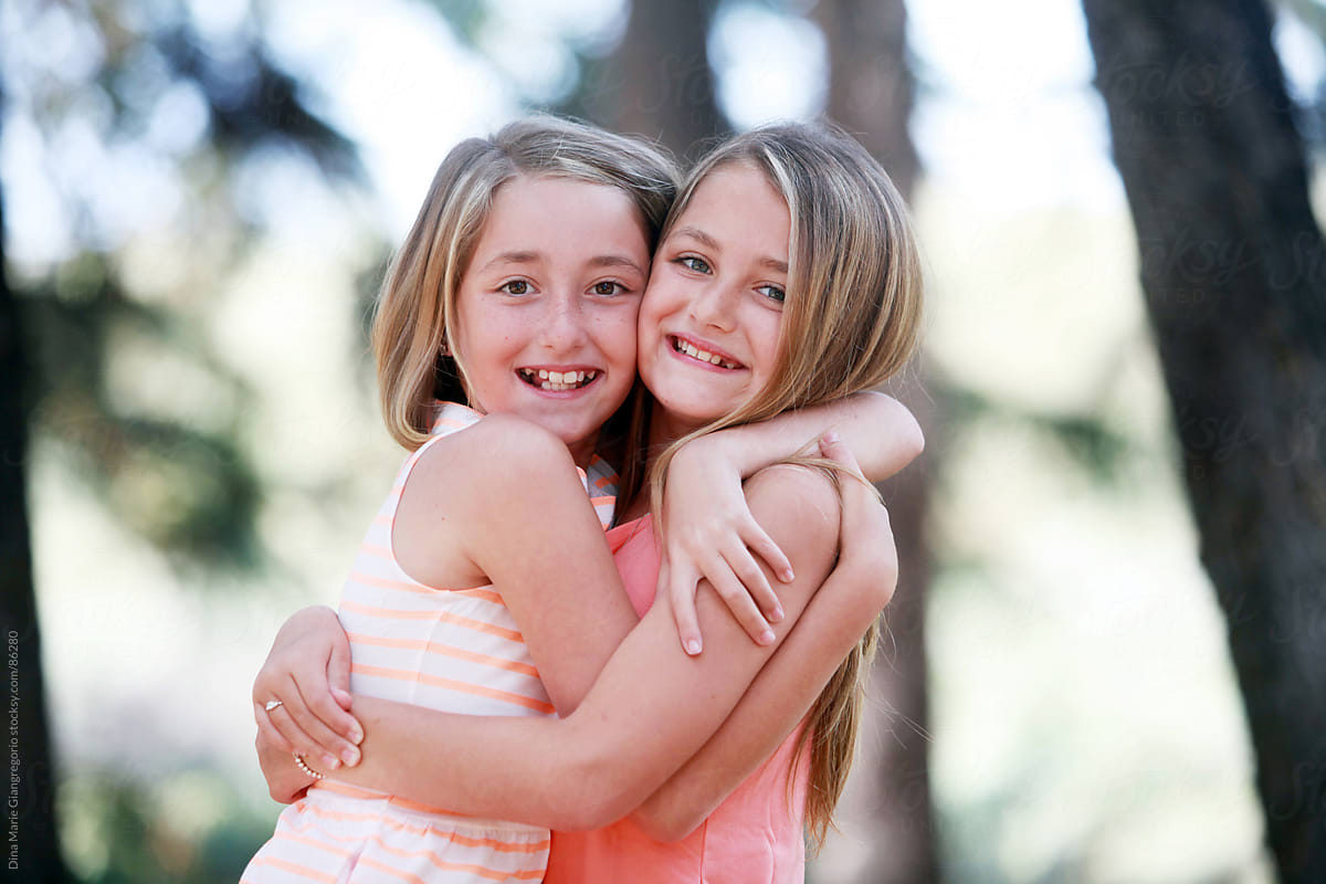 Twin Sisters Hugging Each Other Outdoors By Stocksy Contributor Dina 