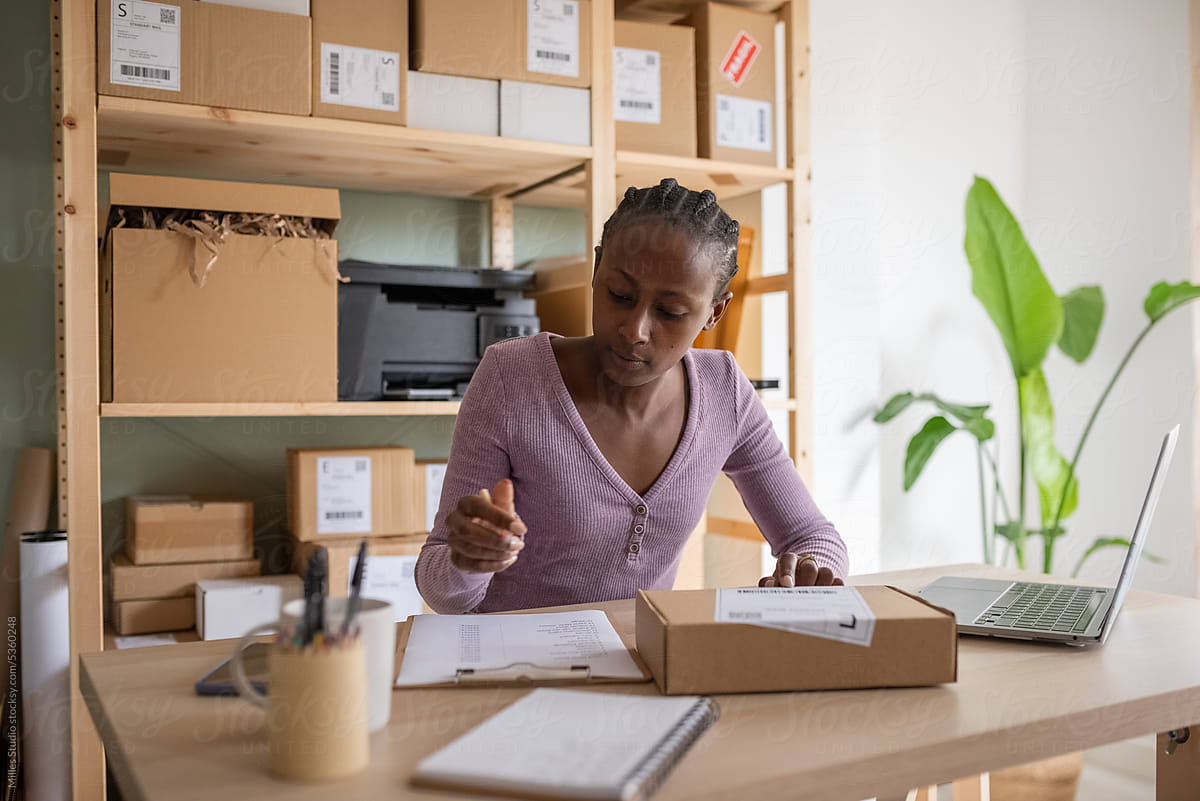 Woman checking data on label before delivering parcel